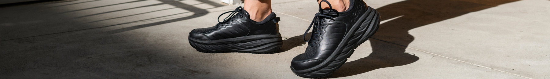 Woman walking in city, wearing HOKA shoes.